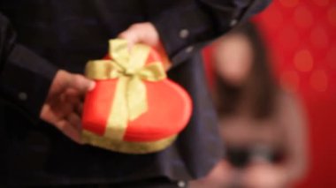 Valentines Day.  Men giving the gift heart shaped box to his girlfriend,